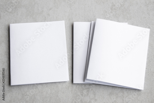 Blank portrait mock-up paper. brochure magazine isolated on gray, changeable background / white paper isolated on gray cement backdrop.