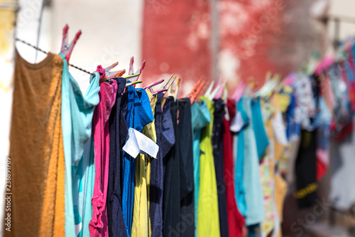 Multicolored clothes hanged and drying in a line outdoors a house, Pylos, Greece.