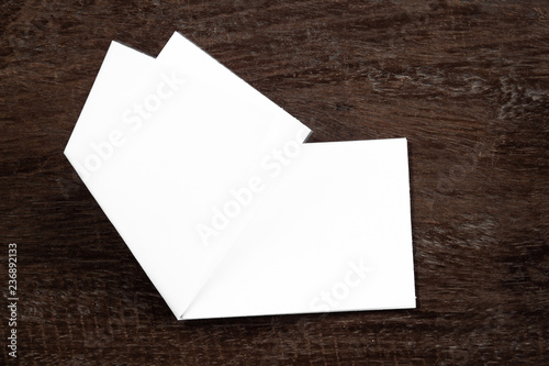 Blank portrait mock-up paper. brochure magazine isolated on brown wooden table, changeable background / white paper isolated on wood