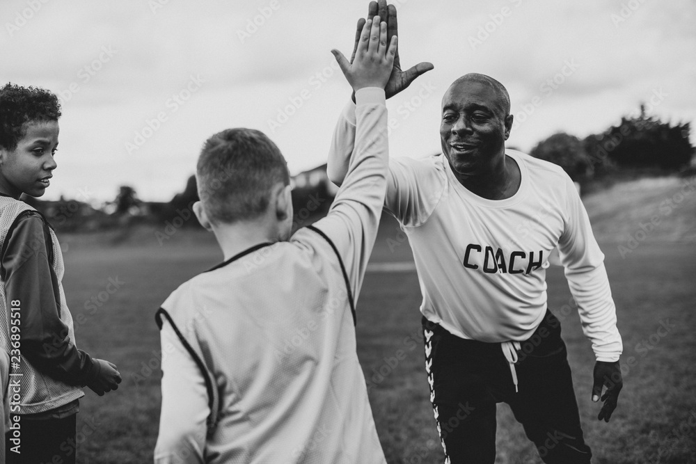 Fototapeta premium Football coach doing a high five with his student