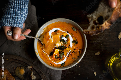 Fotografie Woman eating a creamy pumpkin soup