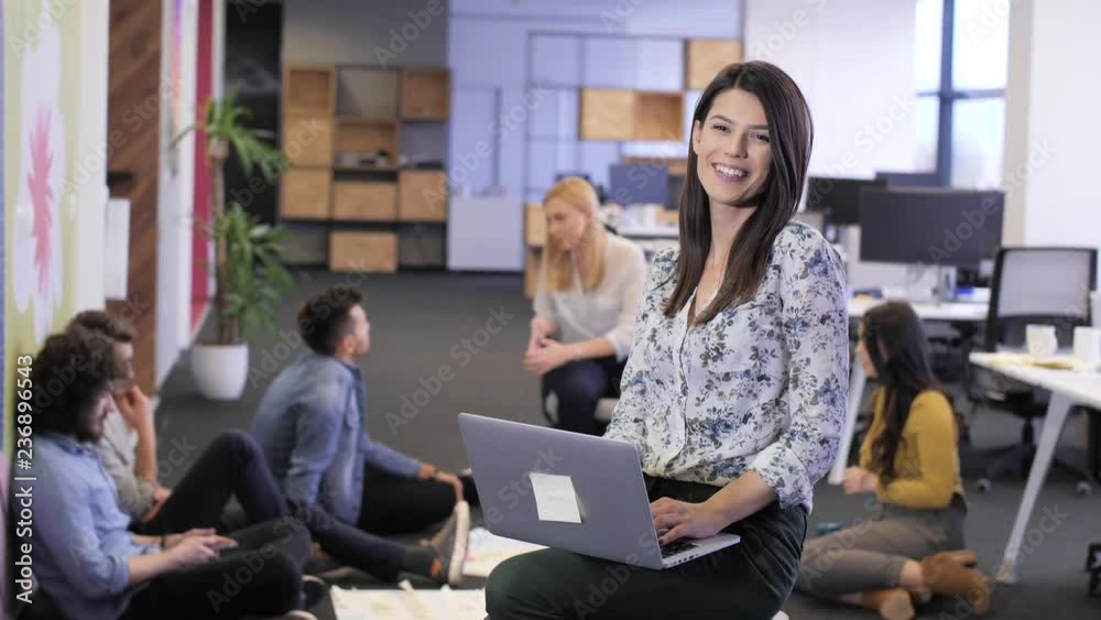 Closeup portrait of pretty cheerful business woman in an office environment holding laptop. Tech office, tech company, tech startup, tech team. Closeup portrait of pretty cheerful business woman in an office environment holding laptop. Tech office, tech company, tech startup, tech team.