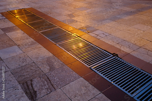 Metal grille drainage on marble floor tiles