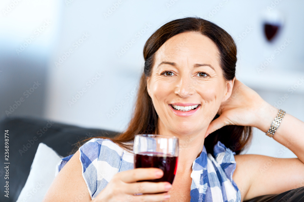 Woman with holding a glass of wine indoors Woman with holding a glass of wine indoors