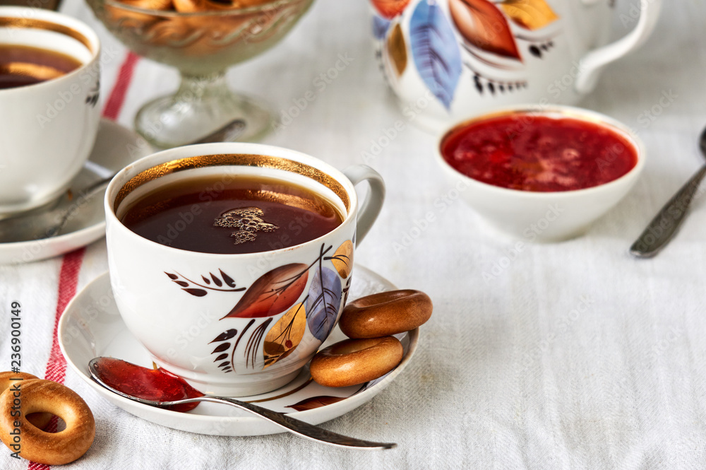 A cup of black tea with bagels and strawberry jam       