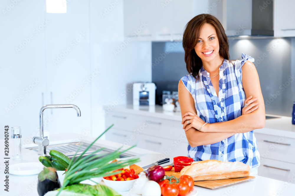 Beautiful woman standing in the kitchen and smiling
