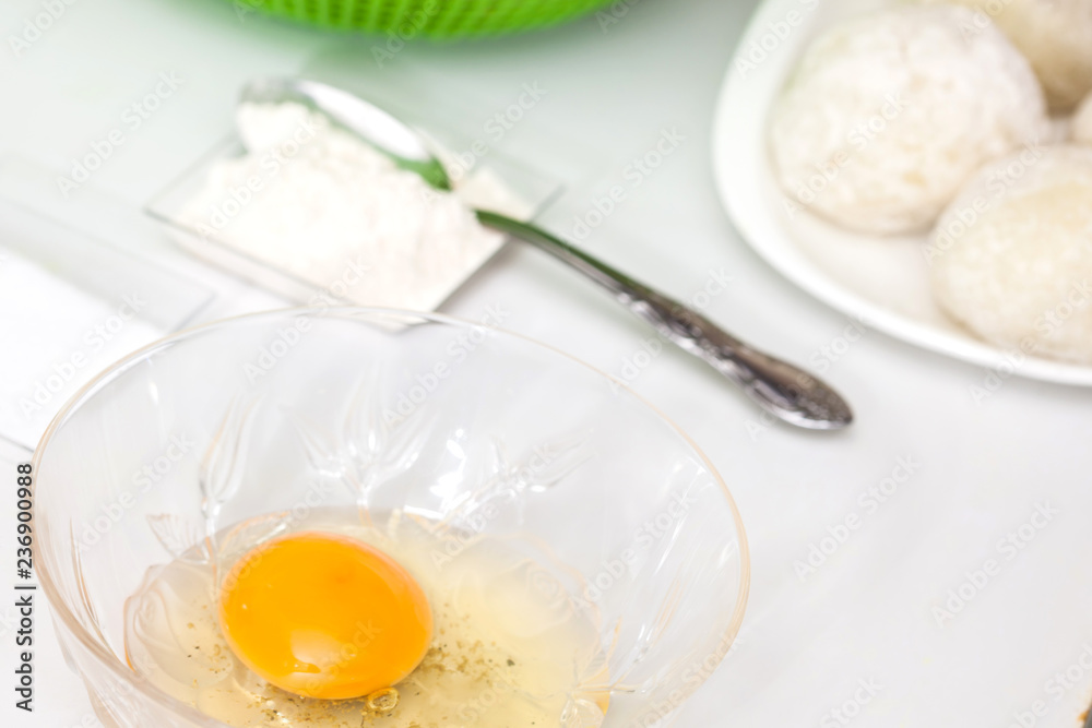 Preparation steps of traditional Colombian dish called stuffed potatoes: Preparing the egg and flour mixture to dunk potatoes