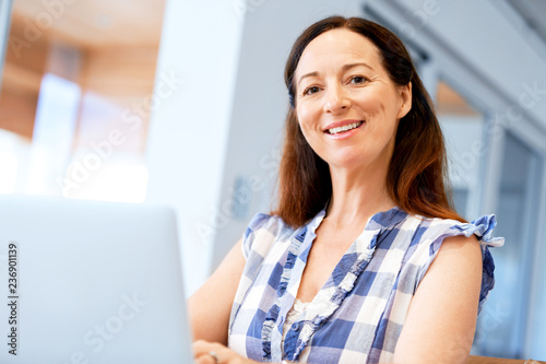 Mature beautiful woman working on her laptop