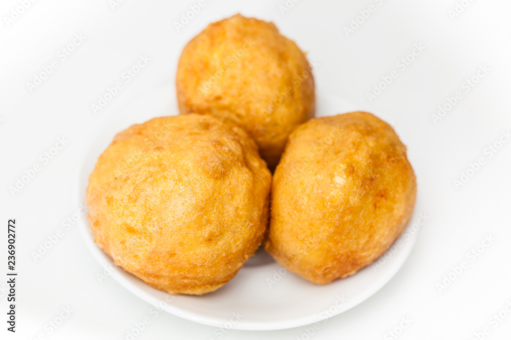 Preparation steps of traditional Colombian dish called stuffed potatoes : Ready stuffed potatoes served in a white ceramic dish isolated on white background