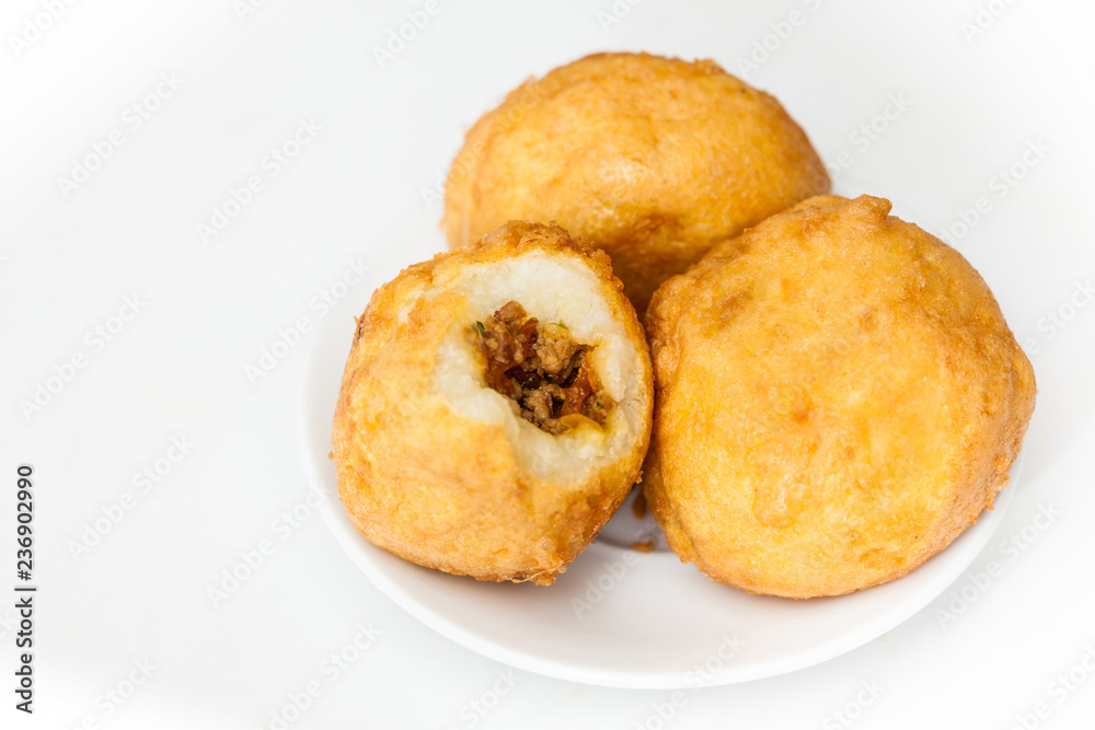 Preparation steps of traditional Colombian dish called stuffed potatoes : Ready stuffed potatoes served in a white ceramic dish isolated on white background