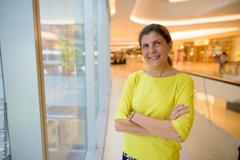 Portrait of happy mature woman smiling inside shopping mall Portrait of happy mature woman smiling inside shopping mall