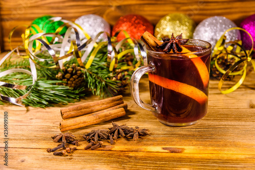 Fototapeta Naklejka Na Ścianę i Meble -  Cup of mulled wine with cinnamon, christmas decorations and fir tree branches on wooden table
