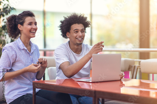 Interracial couple using tablet computer in coffee shop