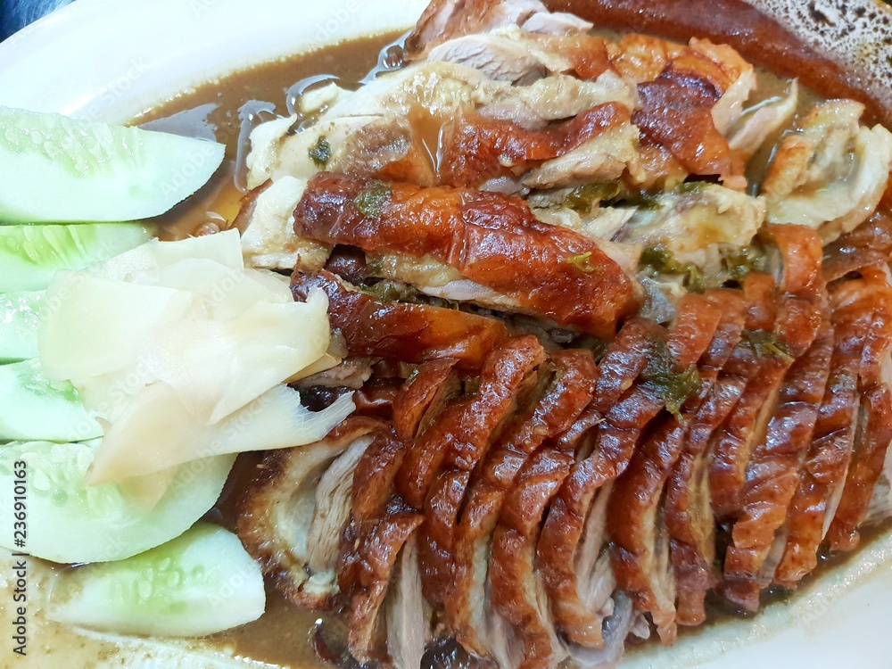 Chinese food style, Top view of roasted duck with cucumber and pickled ginger on plate in restaurant, Sliced peking duck as a background