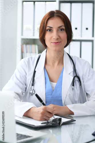 Doctor woman at work. Physician filling up medical history records form at the desk. Medicine, healthcare concept