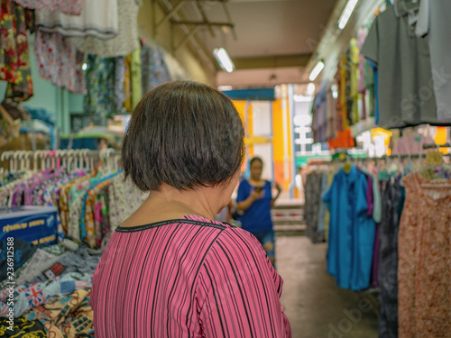 Back of Senior asian women walking and shopping on "Phahurat " Road the Old marketplace in Bangkok City capital of thailand