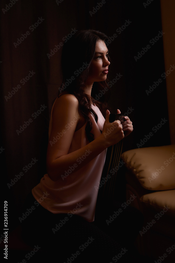 Mysterious portrait of a girl in a light dress in black room. Dark key Mysterious portrait of a girl in a light dress in black room. Dark key