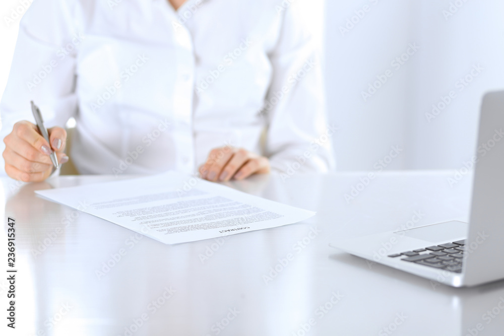 Close-up of female hands with pen over document, business concept. Lawyer or business woman at work in office Close-up of female hands with pen over document, business concept. Lawyer or business woman at work in office