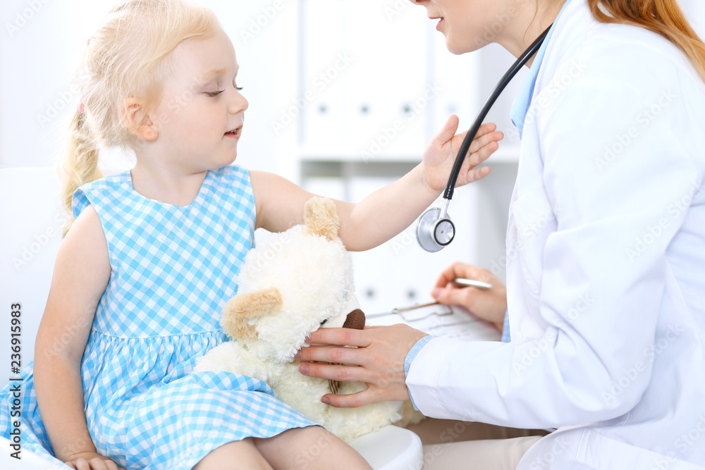 Doctor and a little blonde girl. Usual health exam. Medicine and healthcare concept Doctor and a little blonde girl. Usual health exam. Medicine and healthcare concept