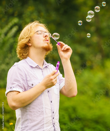 Man blowing soap bubbles outdoor