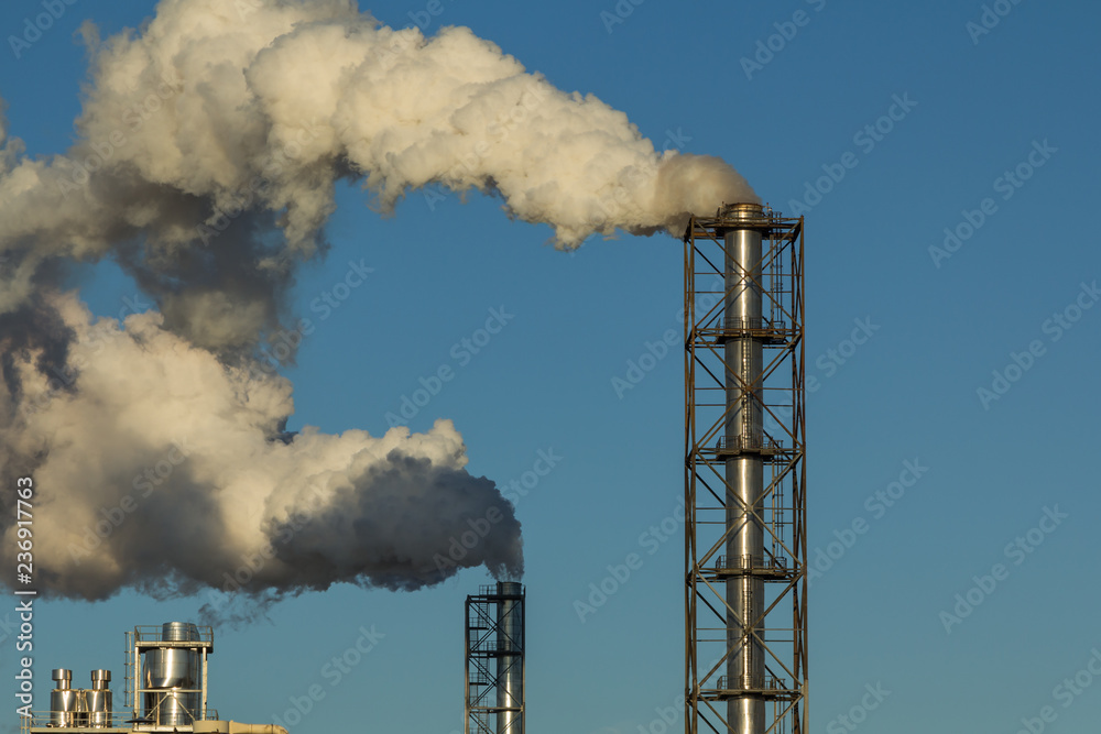 smoking pipes of a woodworking plant against a blue sky smoking pipes of a woodworking plant against a blue sky
