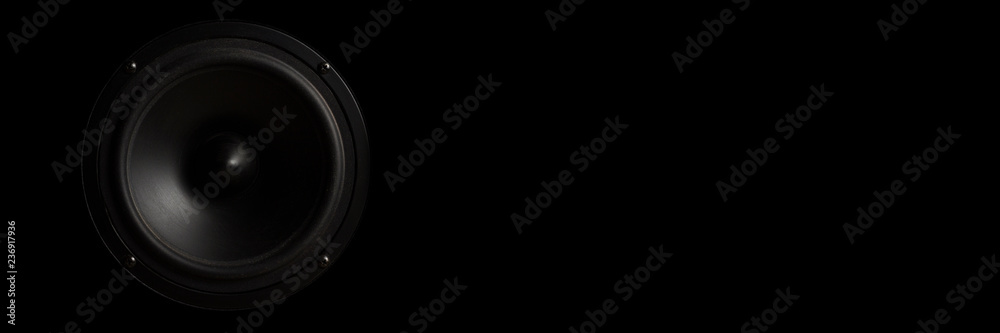 Black Music speaker on a black isolated background. Concept of party or listening to music. Banner Black Music speaker on a black isolated background. Concept of party or listening to music. Banner