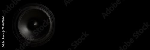 Black Music speaker on a black isolated background. Concept of party or listening to music. Banner