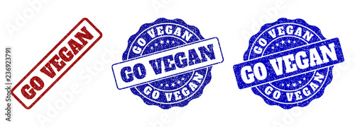 GO VEGAN grunge stamp seals in red and blue colors. Vector GO VEGAN imprints with grunge texture. Graphic elements are rounded rectangles, rosettes, circles and text tags.