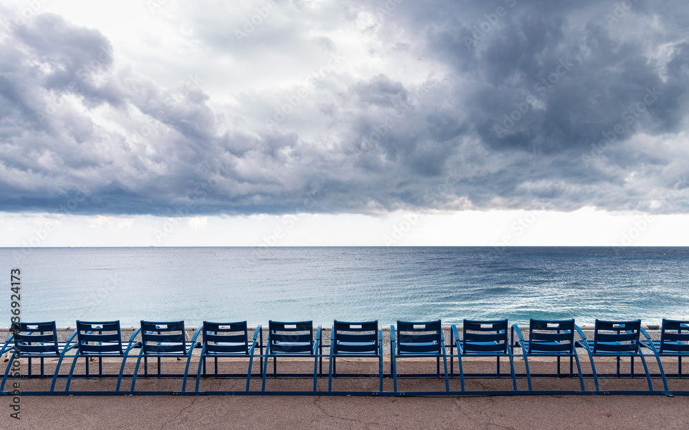 Vacant seat on view point rest area with background of dark clouds cover mediterranean sea of Nice, France.