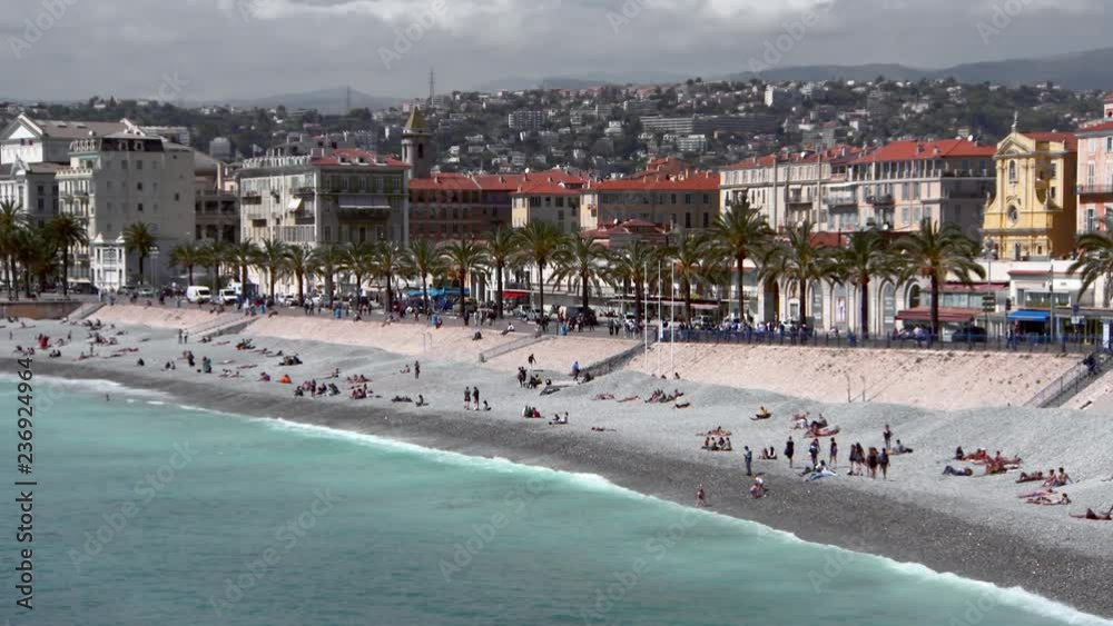 Pan: Tourists Sunbathe on the Beach at Nice