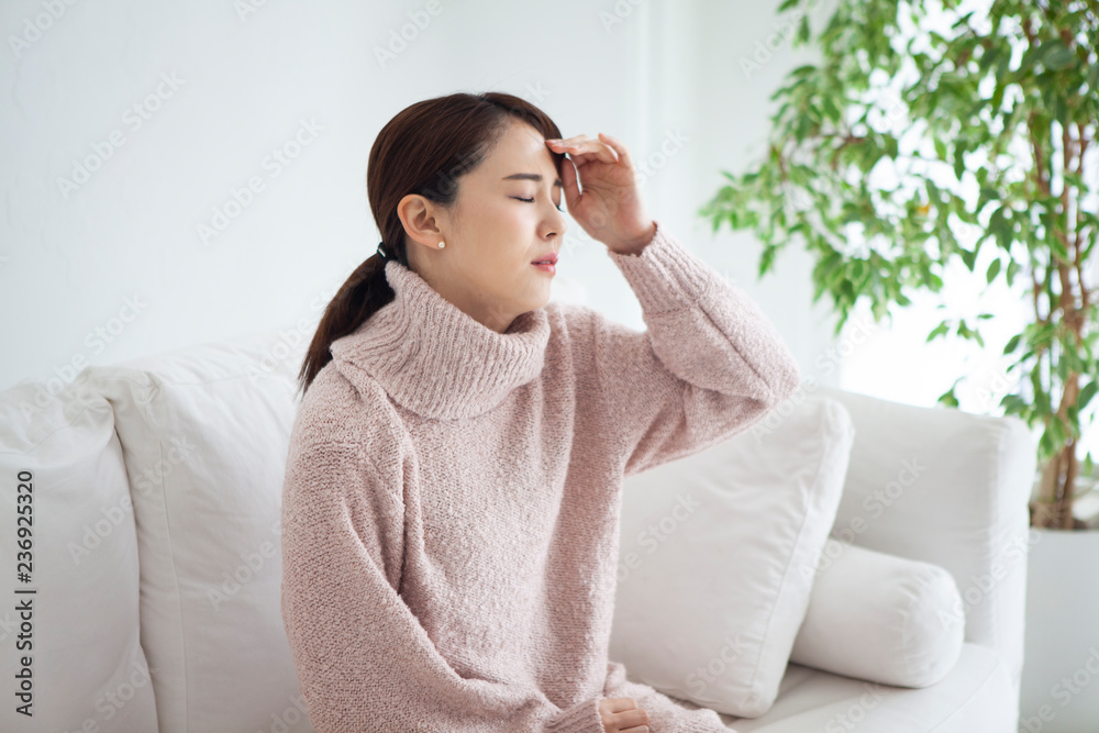 自宅で頭痛と発熱に悩む女性 自宅で頭痛と発熱に悩む女性