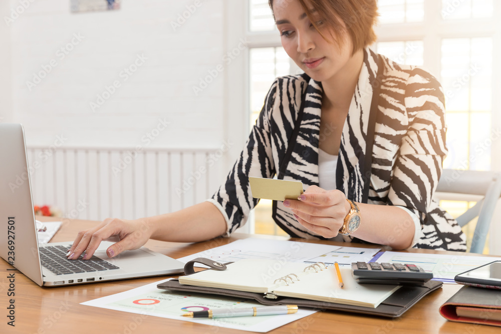 Businesswoman holding credit card and using laptop to shopping online