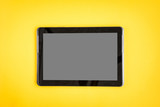 Tablet on yellow background.
