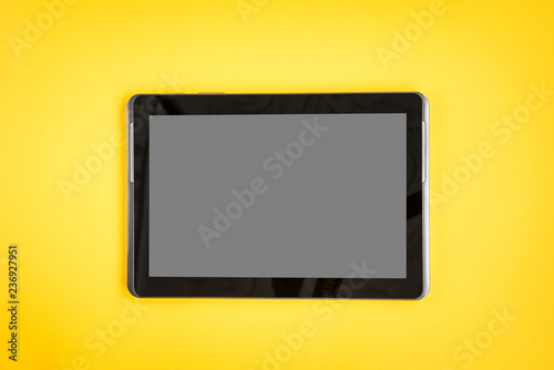 Tablet on yellow background.