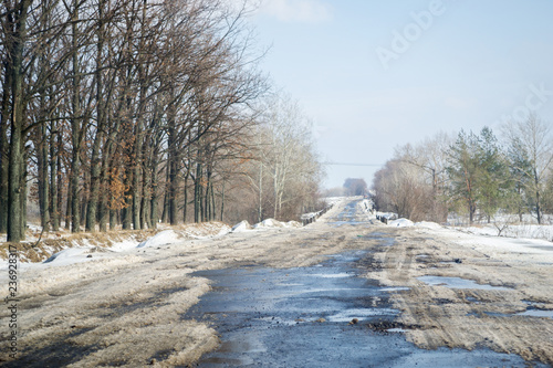 Driving on a snowy road in winter or early spring. View from the car window.