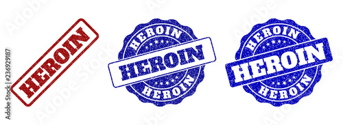 HEROIN grunge stamp seals in red and blue colors. Vector HEROIN labels with grunge style. Graphic elements are rounded rectangles, rosettes, circles and text labels.