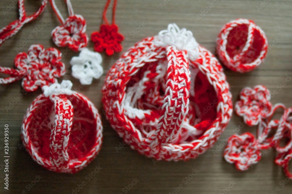 Martenitsa, white and red strains of yarn, Bulgarian folklore tradition, welcoming the spring in March, symbol, wish for good health. Crochet basket and flowers pendants. Baba Marta Day. Martenitsa, white and red strains of yarn, Bulgarian folklore tradition, welcoming the spring in March, symbol, wish for good health. Crochet basket and flowers pendants. Baba Marta Day.