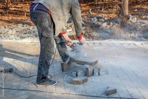 A worker prepares a sidewalk for paving a footpath.