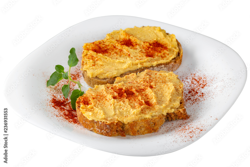 Two open sandwiches with hummus and paprika powder on plate Two open sandwiches with hummus and paprika powder on plate