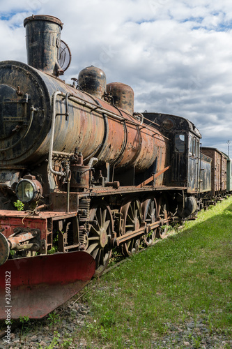 Steam locomotive standing on some old railroad track in sunshine