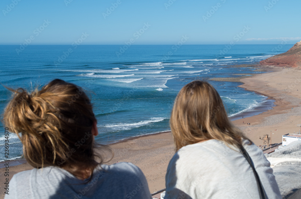 Two people looking at the waves in Sidi Ifni, Morocco.