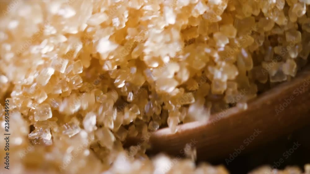 Slow motion closeup shot wooden spoon picking brown sugar in the bowl