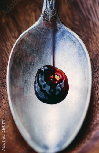Fényképezés Italian wine balsamic vinegar is poured into a spoon closeup macro