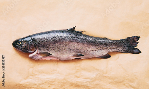 Fresh rainbow trout on brown paper top view
