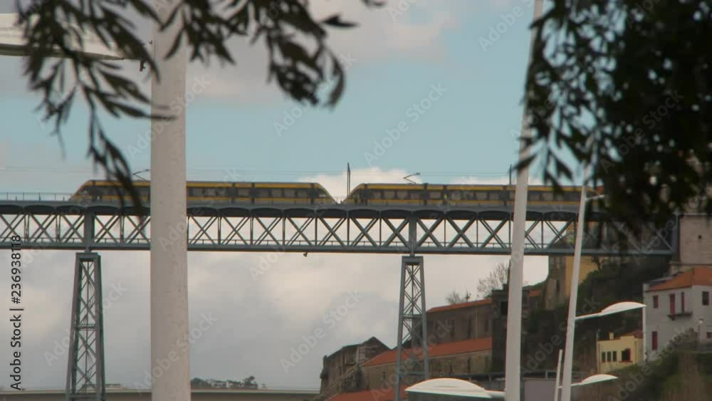 Close Up Pan of Yellow Train Riding Over Bridge on a Windy and Cloudy Day Close Up Pan of Yellow Train Riding Over Bridge on a Windy and Cloudy Day