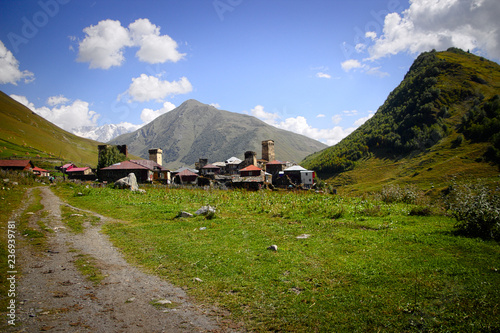 Village Ushguli landscape with massive rocky mountains Bezengi wall, Shkhara on the background in Svaneti, Georgia