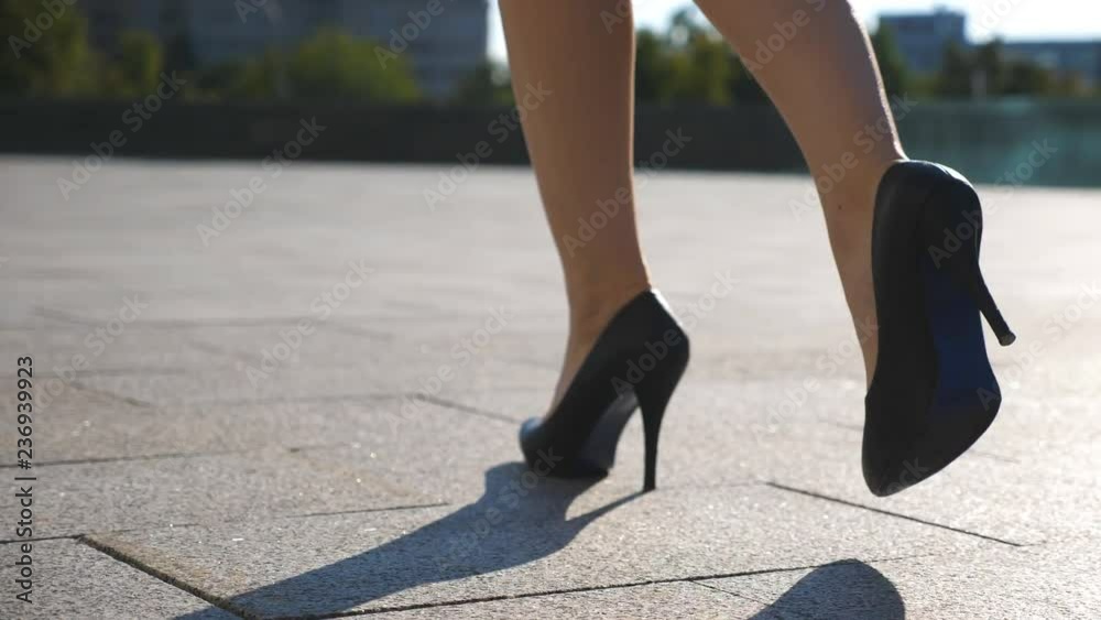 Female legs in high heels shoes walking in the urban street. Feet of young business woman in high-heeled footwear going in the city. Girl stepping to work. Slow motion Close up Female legs in high heels shoes walking in the urban street. Feet of young business woman in high-heeled footwear going in the city. Girl stepping to work. Slow motion Close up