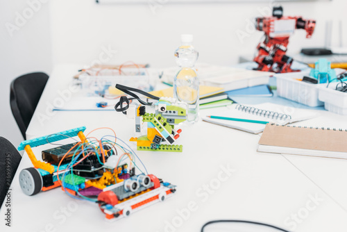 handmade robot models and school supplies on table in STEM classrom