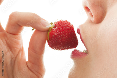 Mädchen isst genussvoll eine Erdbeere