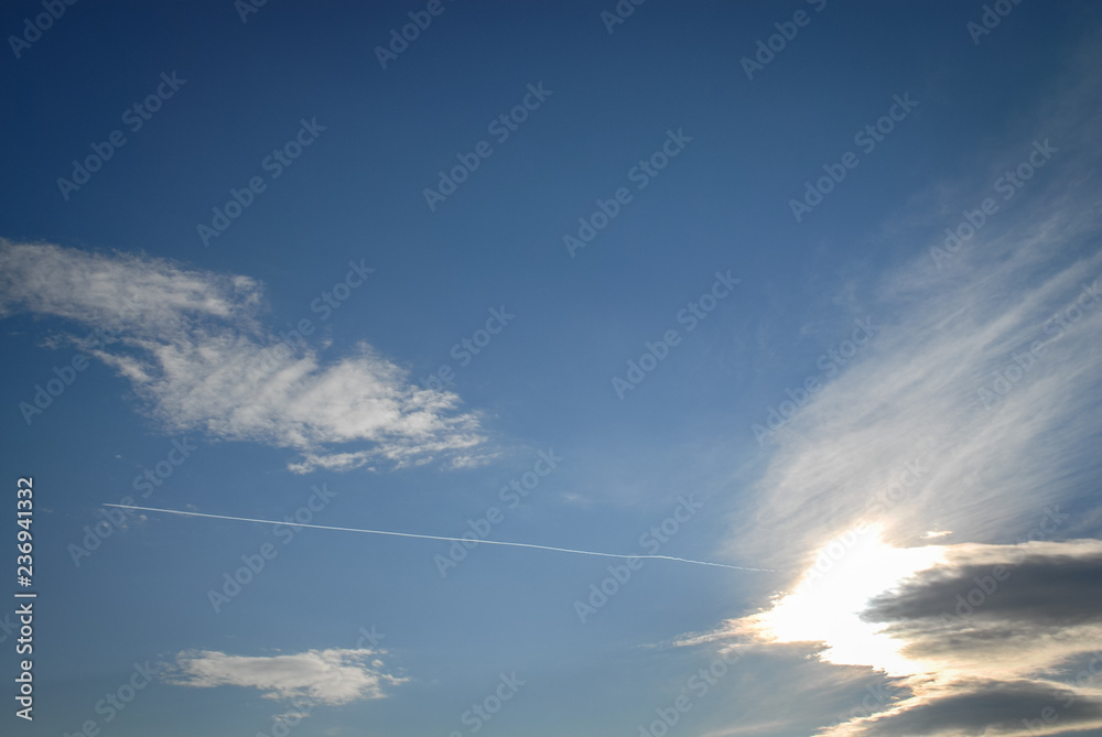 Clouds in the sky and an aeroplane smoke line. Smoke line in the blue sky. Clouds in the sky. Clouds in the sky and an aeroplane smoke line. Smoke line in the blue sky. Clouds in the sky.